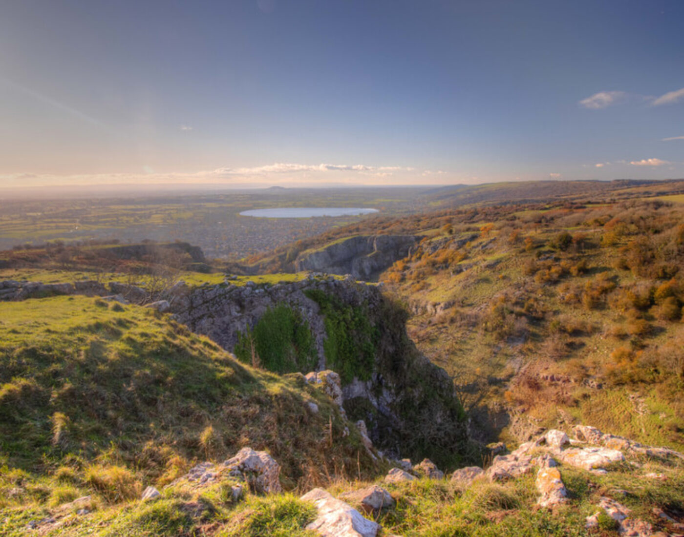 A view from the top of a cliff overlooking a lake.